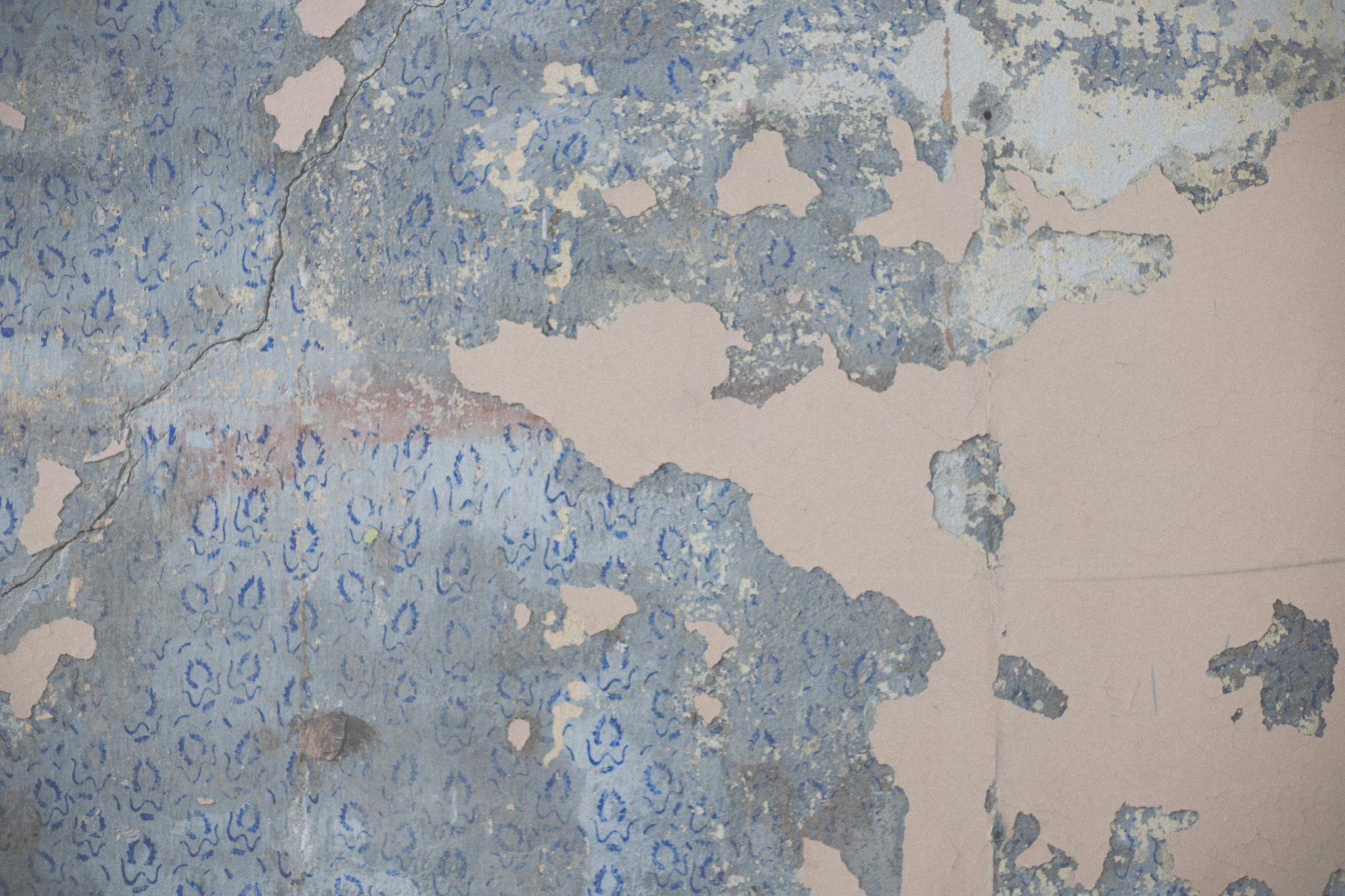 Interior wall showing peeling paint and moisture damage from prolonged water exposure